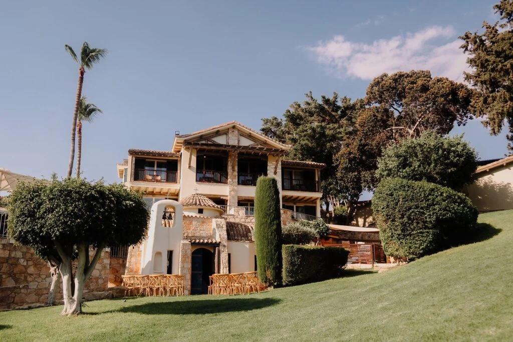 Stone villa with a dance floor and dinner tables set out on the lawn