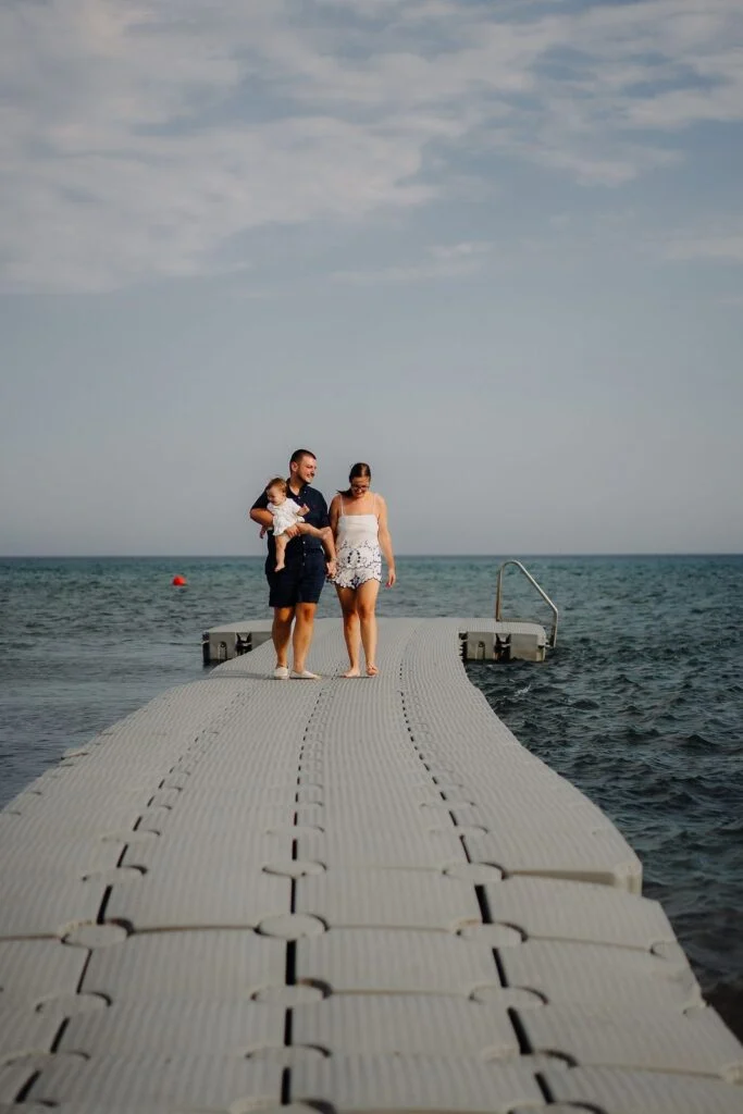Family walking along a wooden jetty out over the sea