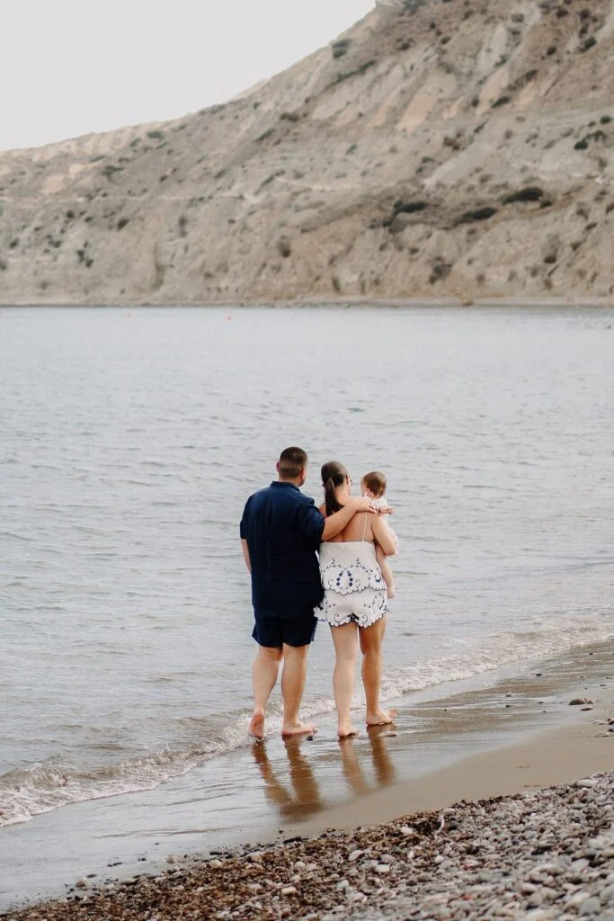 Father holding his daughter on the jetty above the sea