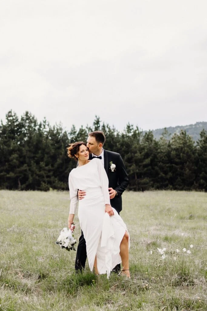 Bride and groom embracing among the narcissus in the meadow