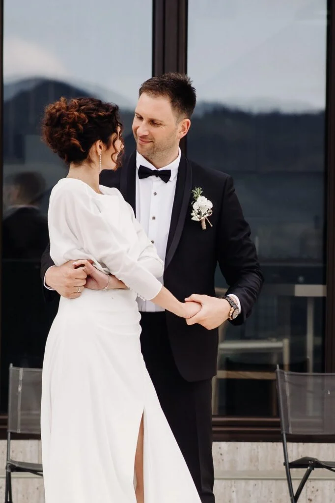 Bride and groom on a terrace with the mountains behind them