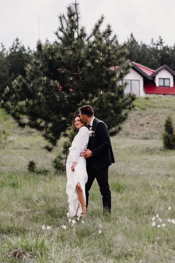 Bride and groom among young pines on the mountain