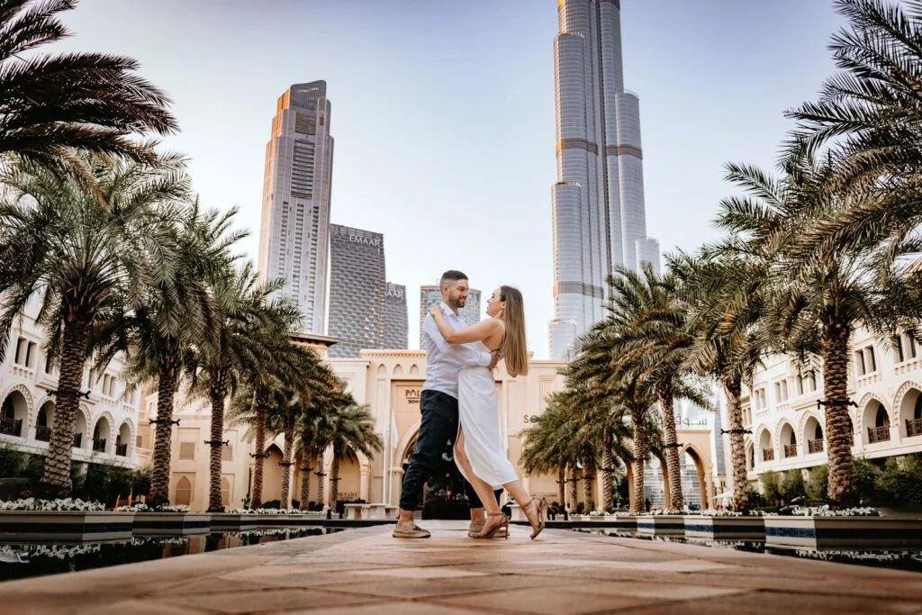 Couple dancing on a palm lined walkway beneath the towers of Dubai