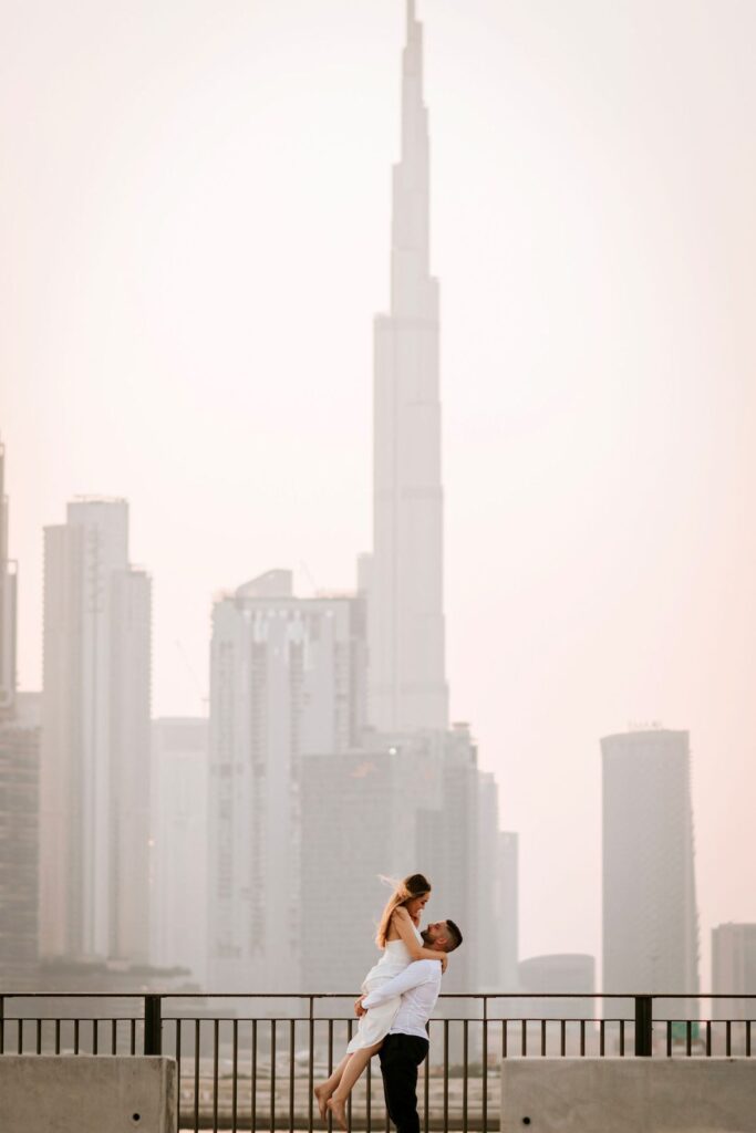 Couple small against the Dubai skyline seen through haze