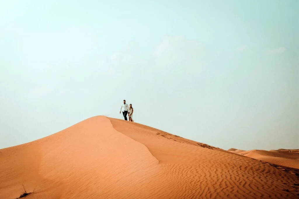 Couple standing on the crest of a desert dune