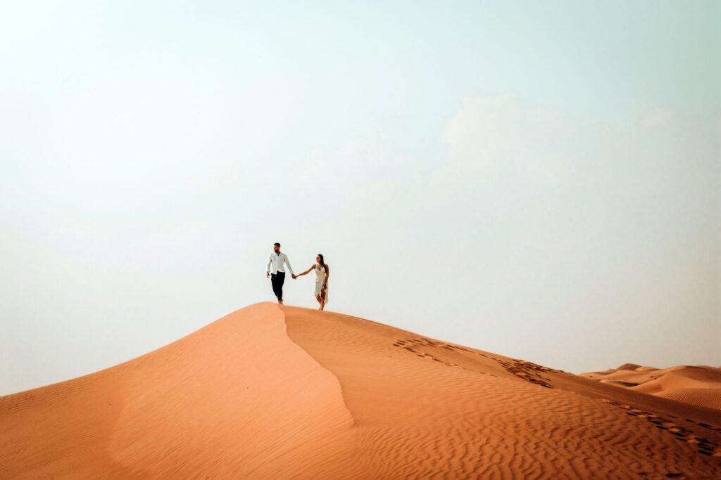 Couple hand in hand on the ridge of a sand dune