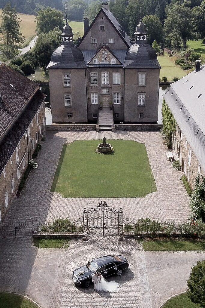Aerial view of the castle courtyard in Germany with a black car on the cobbles
