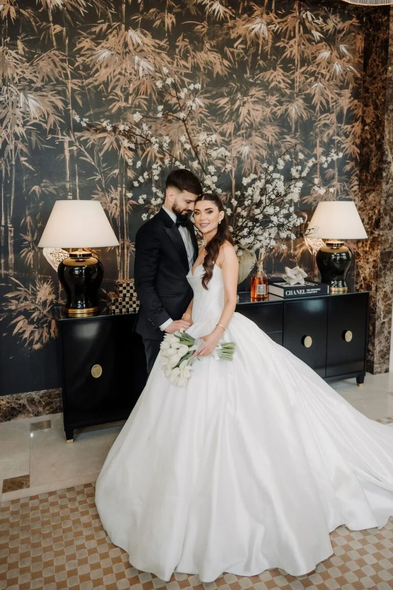 Bride with her gown spread wide against floral wallpaper at Hotel Bristol