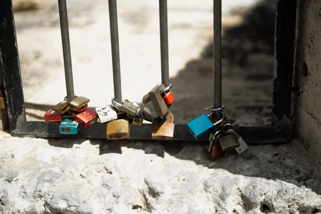 Padlocks fastened to an iron railing above the rocks