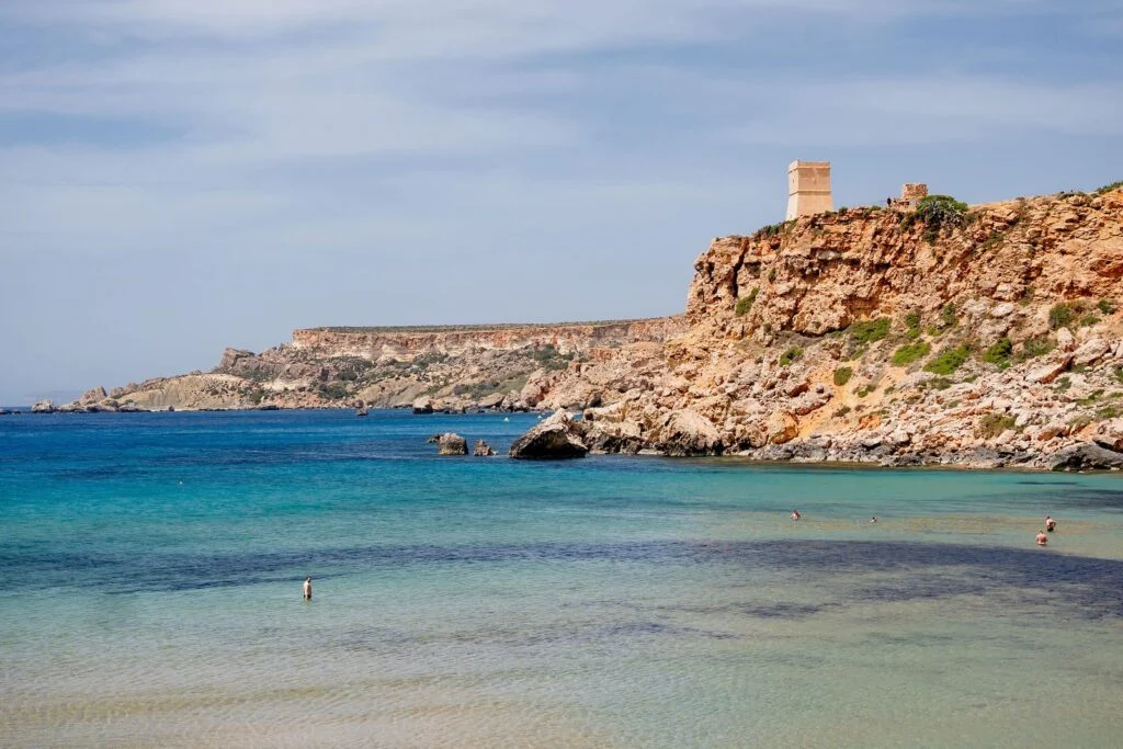 Bay in Malta with turquoise water and a watchtower on the headland