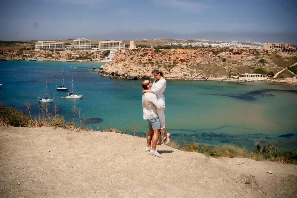 Couple at the water's edge with the bay behind them