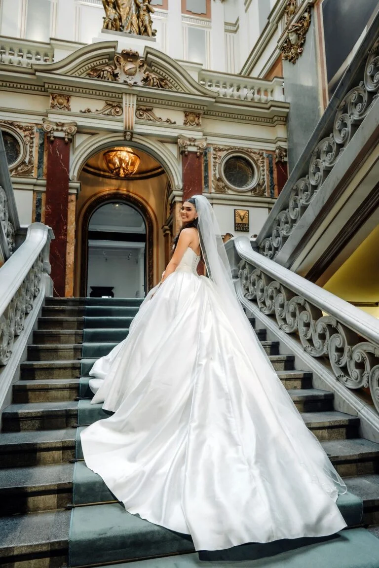 Bride on the grand staircase at Salon 1905 in Belgrade, her gown spread across the steps