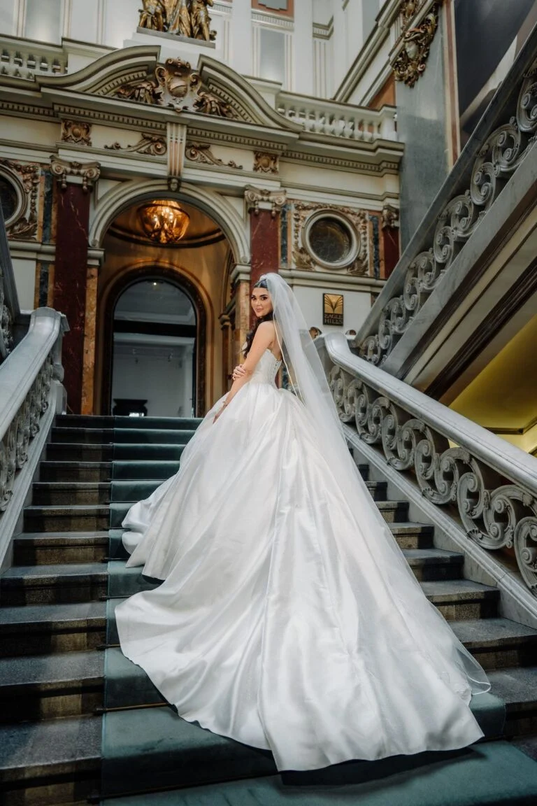 Bride walking up the marble staircase at Salon 1905, train trailing behind her