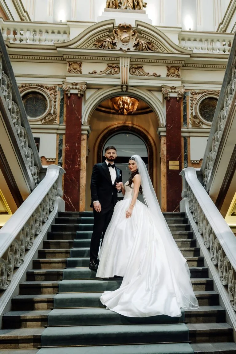 Bride and groom on the staircase at Salon 1905, her veil drawn over her face
