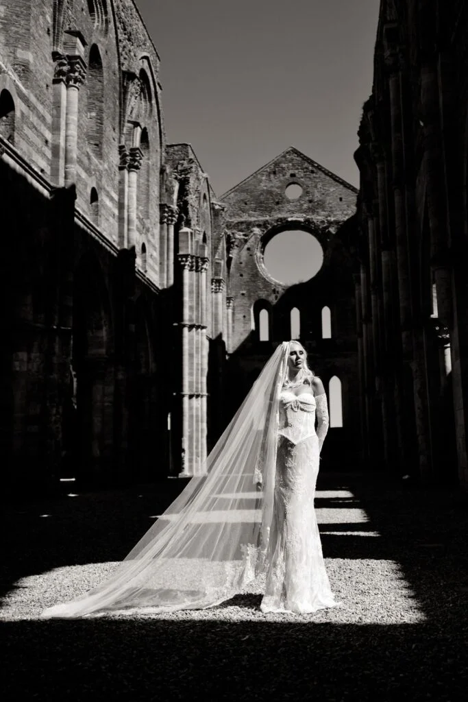 Black and white photograph of the bride with a long veil inside the abbey