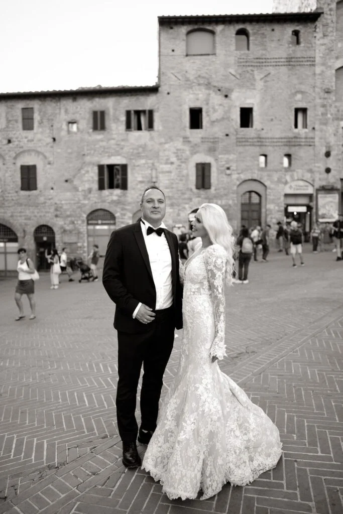 Black and white photograph of the couple in a medieval town square in Tuscany