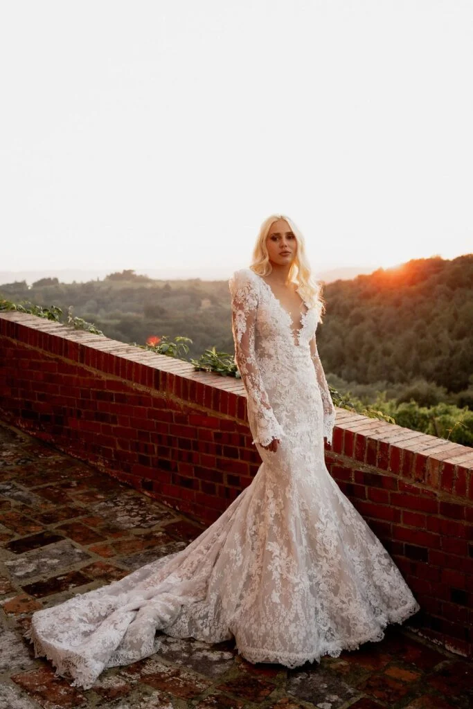 Bride standing at the terrace wall with the Tuscan hills behind her