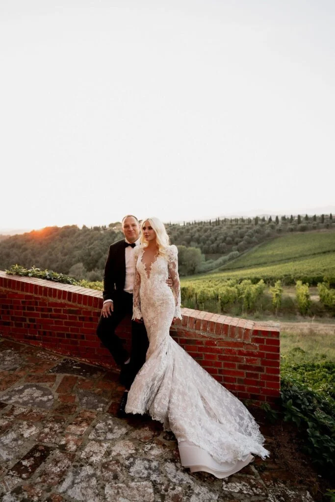 Bride and groom seated on the brick terrace above the vineyards